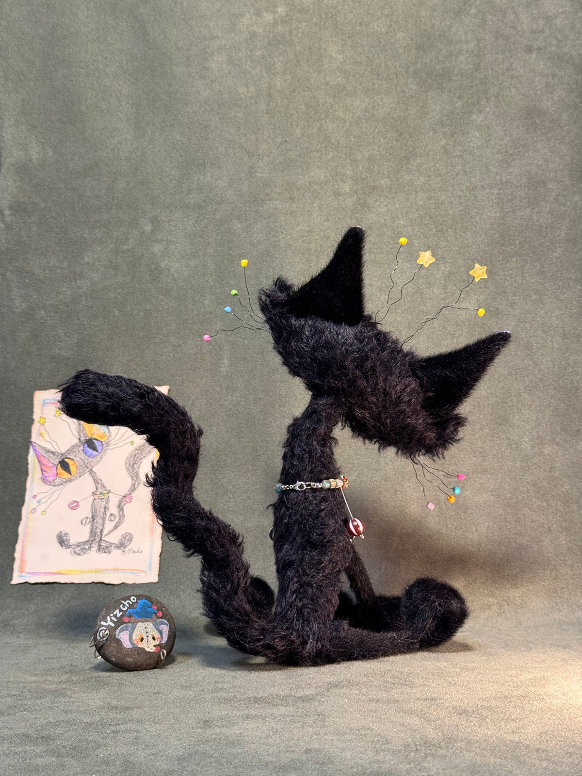 Back view of the exact black cat art doll showing its long curled tail
