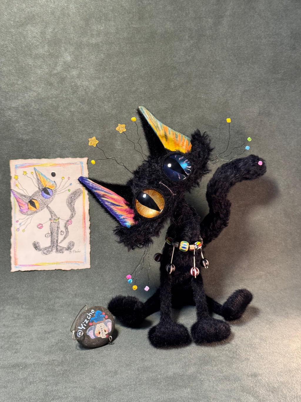 Front view of the Halloween black cat with its included original colored hand-drawn sketch; the stone tag is a display prop