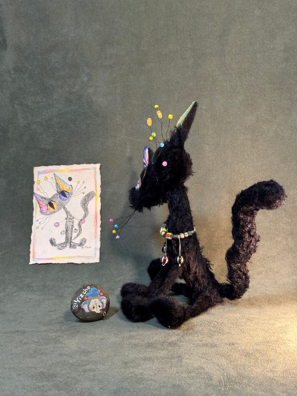Side view of the black cat art doll and its hanging beaded accessories