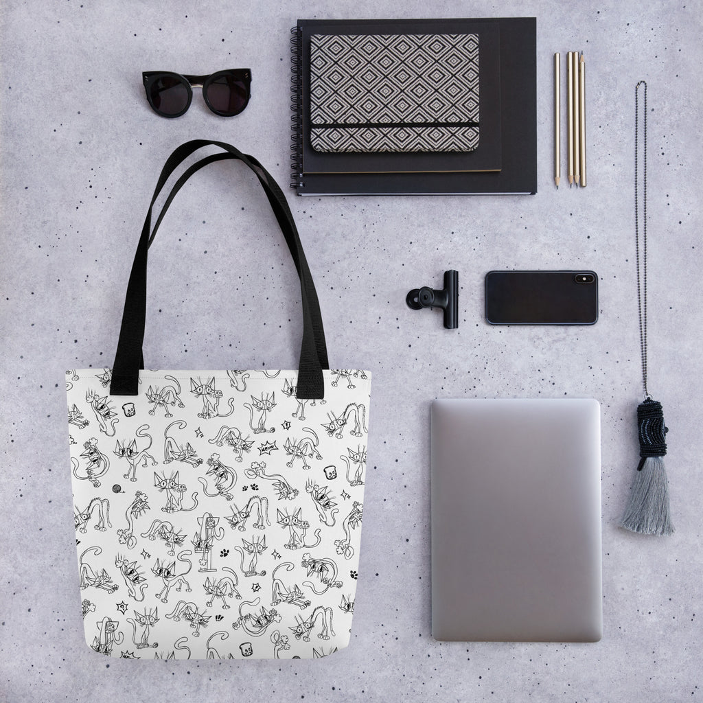 Printful flat-lay mockup of the Yizcho Cat Parade tote beside a laptop and desk accessories; props are not included.