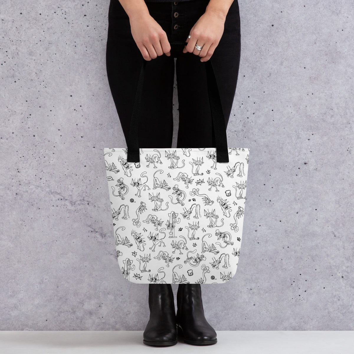Printful mockup of a person holding the Yizcho Cat Parade tote with black handles.