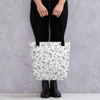 Printful mockup of a person holding the Yizcho Cat Parade tote with black handles.