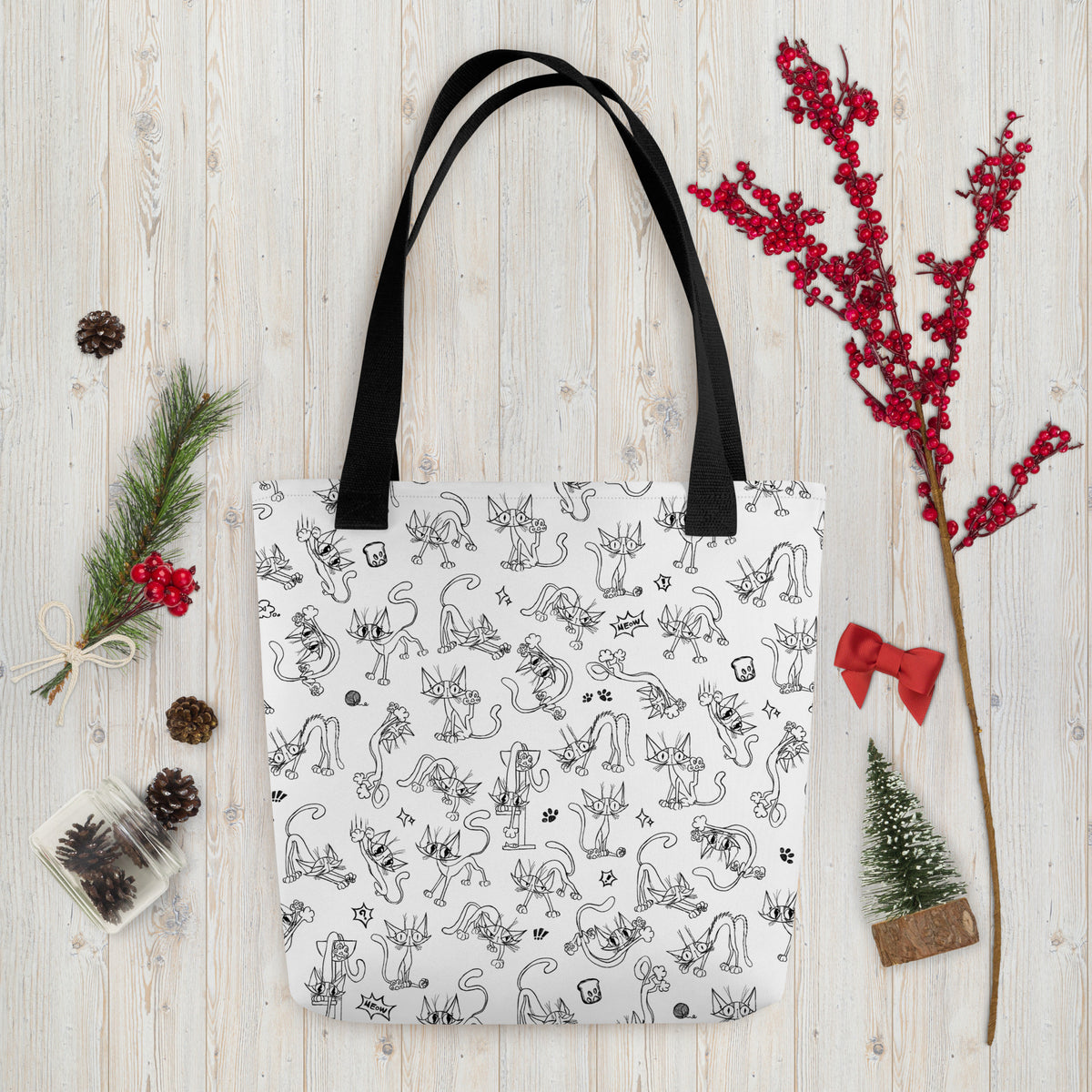 Printful holiday flat-lay mockup of the Yizcho Cat Parade tote on a wooden surface; props are not included.