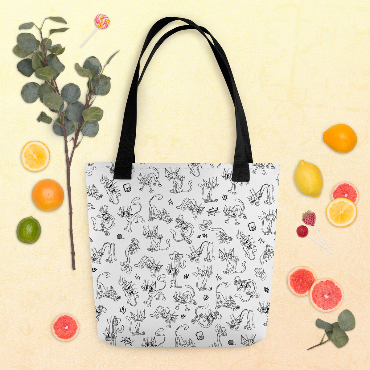Printful spring and summer flat-lay mockup of the Yizcho Cat Parade tote with citrus on a yellow background; props are not included.